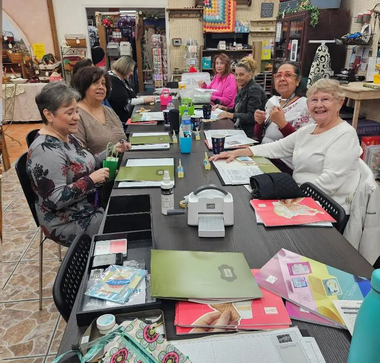 A group of women sitting at a table with papers.