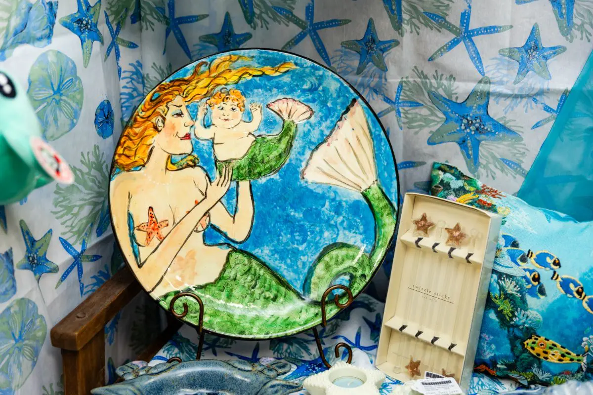 A plate with a picture of a mermaid and a baby.