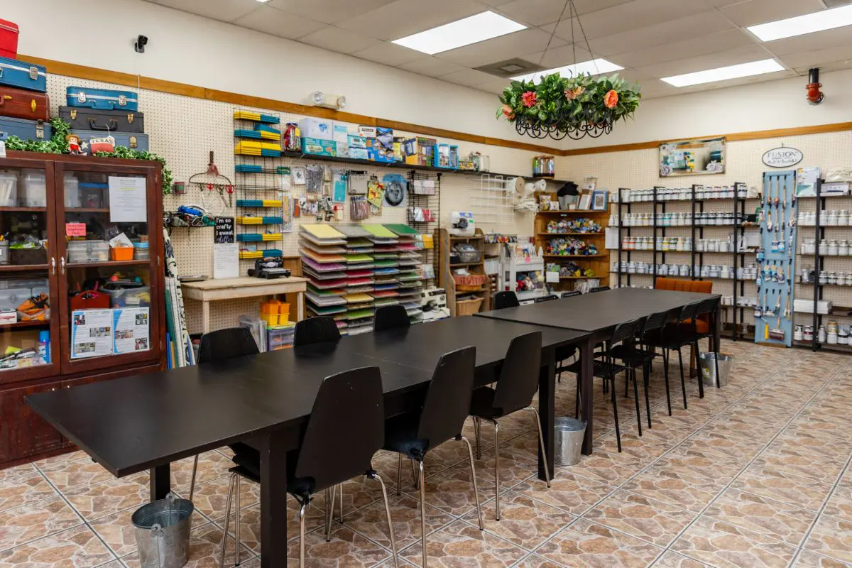 A large table with chairs in front of shelves.