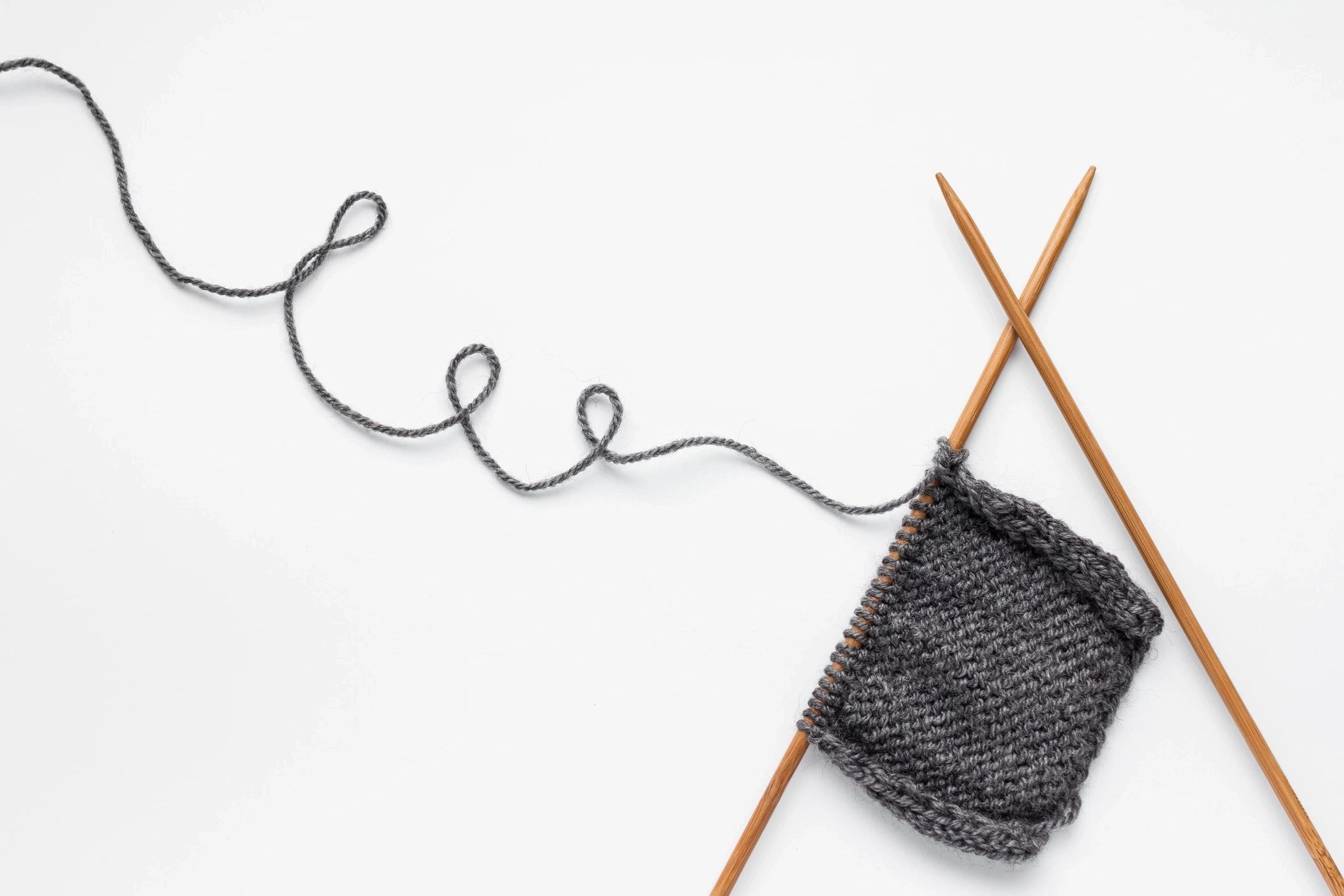 Grey yarn on knitting needles.