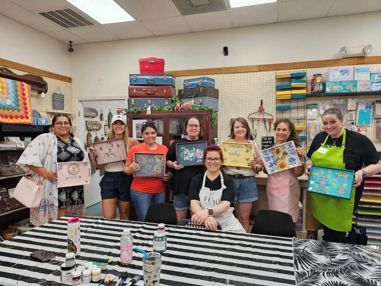 Group of women painting decorative trays.